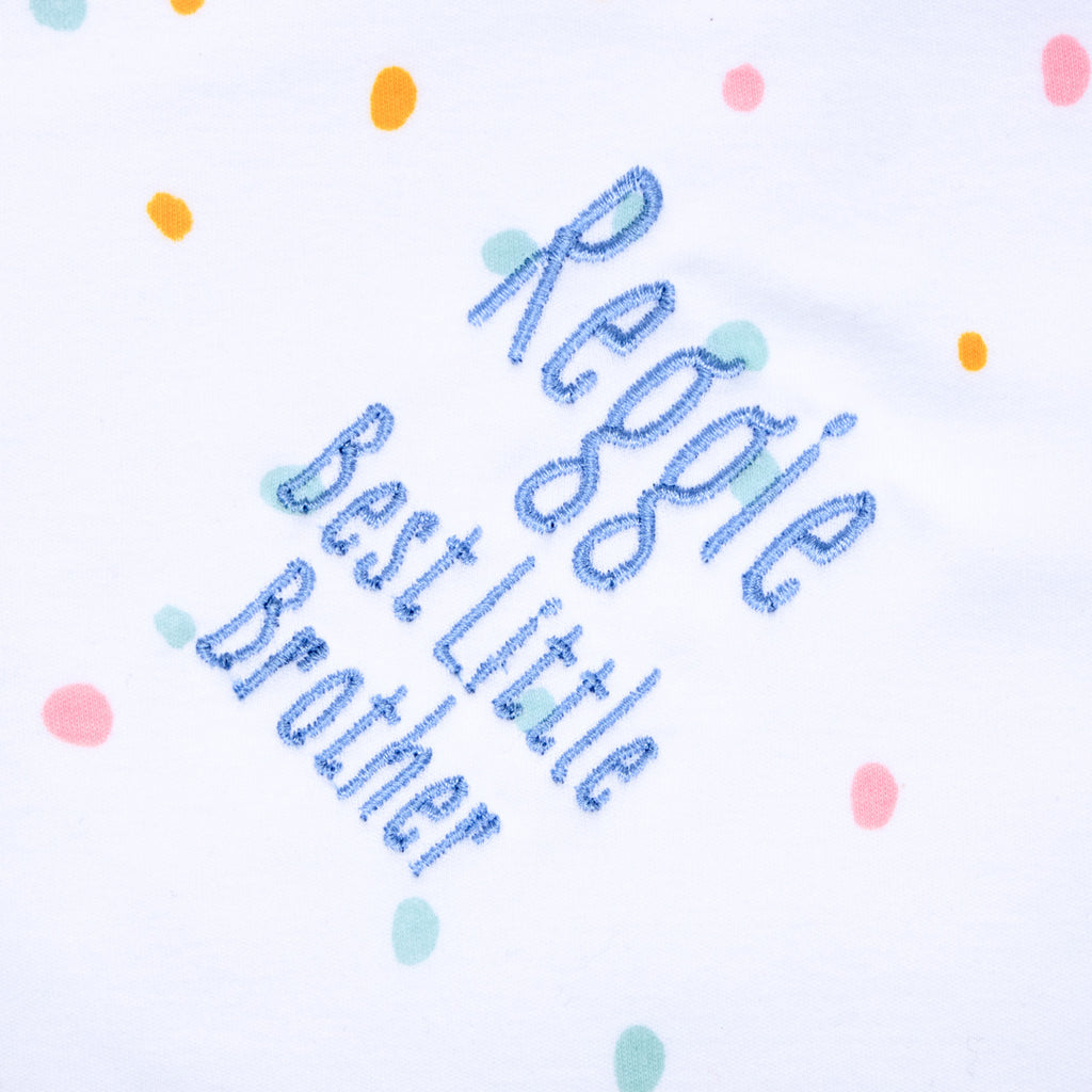 Close up of the words "Reggie, Best little Brother" embroidered in blue thread on a Personalised baby Blanket in neutral pastel colours 