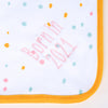 Close up of the words "Born in 2021" embroidered in pink thread on a Personalised baby Blanket in neutral pastel colours with an orange trim.