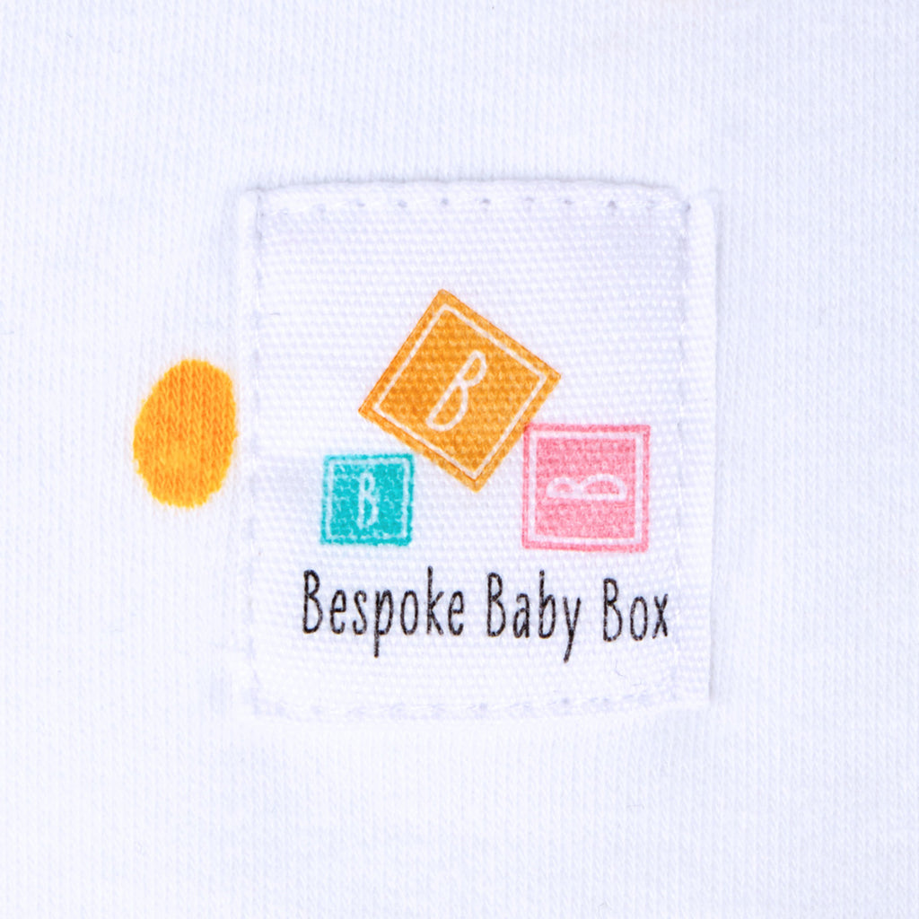 Close up of the Bespoke Baby Box logo label on a baby Blanket in neutral pastel colours 